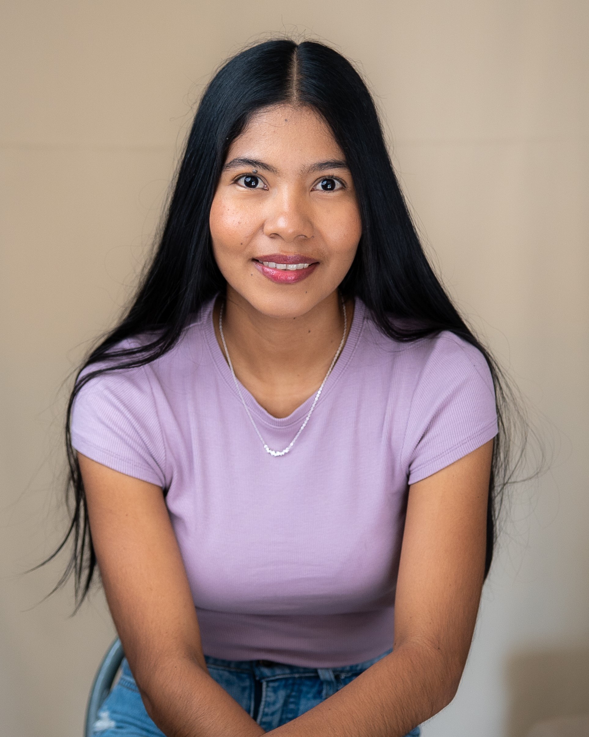 Retrato de Keisy Jiménez, psicóloga, sonriendo frente a un fondo beige